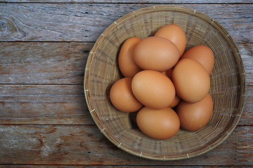 Fresh eggs in basket on wooden background