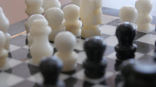 Couple Playing Chess Game On A Chess Board