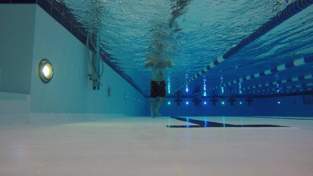 An underwater shot of a man swimming for camera