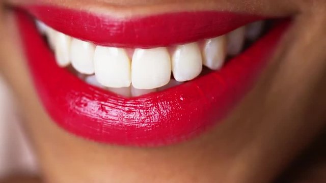 Closeup of a woman smiling with red lipstick