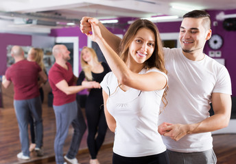 Happy adult couples enjoying of partner dance indoor