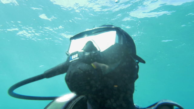 Scuba diver in blue water on sunny day