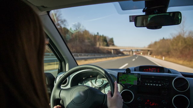 Person in car setting navigation while driving