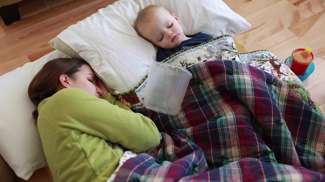 a toddler with the flu lying next to mother