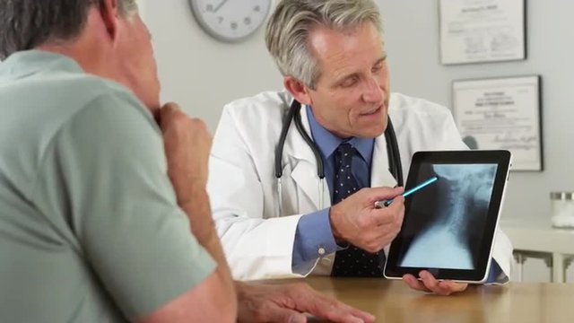 Mature Doctor consulting senior patient about his xrays