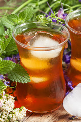 Ice black tea with herbs, selective focus