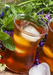 Ice black tea with herbs, selective focus