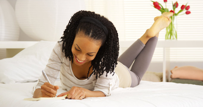 Young black woman writing in journal