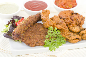 South Asian Starters - Selection of seekh and shami kebabs, mushroom and chicken pakoras and onion bhajjis. Served with salad, mint raita, lime pickled and chilli sauce.
