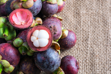 Mangosteen and cross section showing the thick purple skin and w