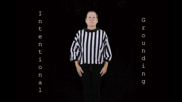 Woman dressed as a football referee signaling Intentional Grounding.