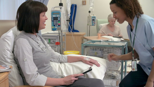 Nurse Checking On Female Patient Having Chemotherapy 