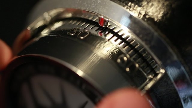 hand opening a combination lock on a vault