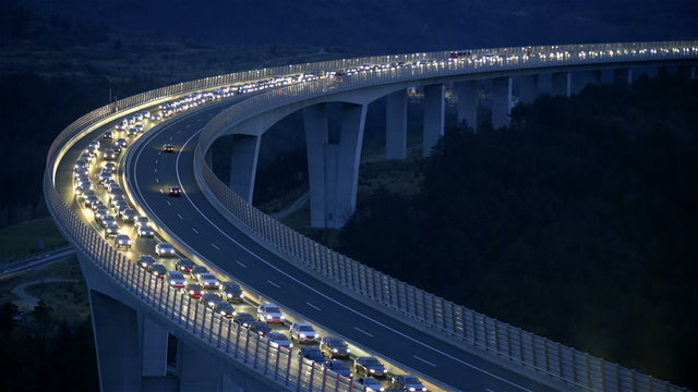 Vehicles standing in traffic jam with lights shining at night