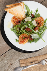 Salad with pancetta, paemesan cheese and dried tomato.