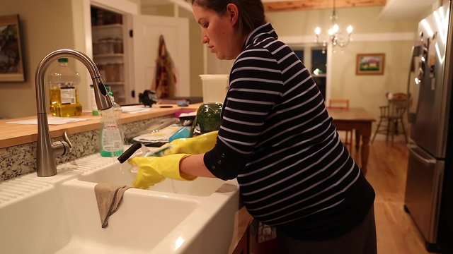 pregnant woman washing dishes at the kitchen