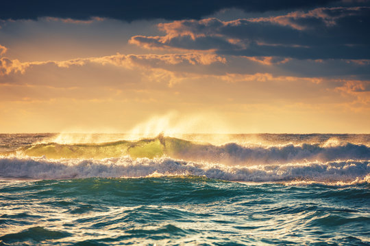 Fototapeta Sunrise and shining waves in ocean