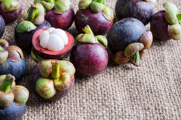 Mangosteen and cross section showing the thick purple skin and w
