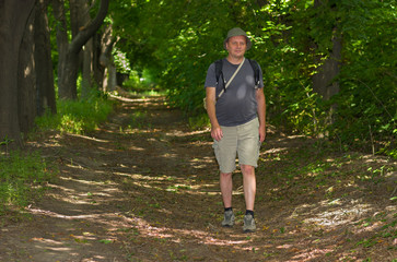 Mature man hikes at summer forest