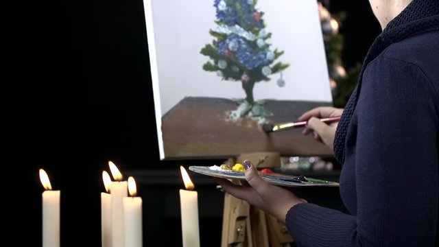 Artist drawing Christmas with candles in front