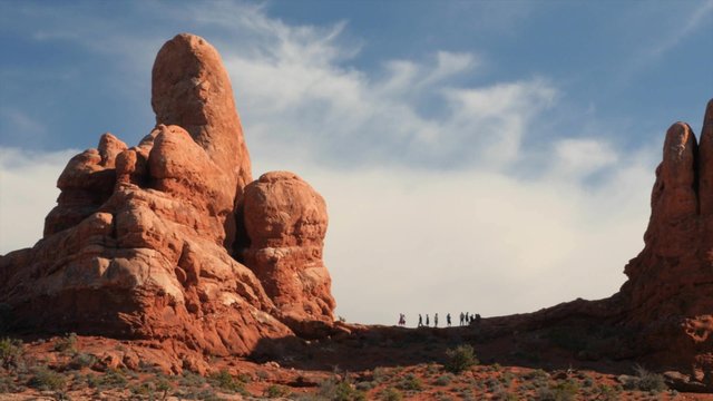 Hikers at turret arch in arches national park
