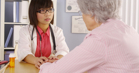 Asian doctor explaining brain scans to elderly patient