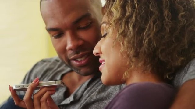 African couple talking on smartphone