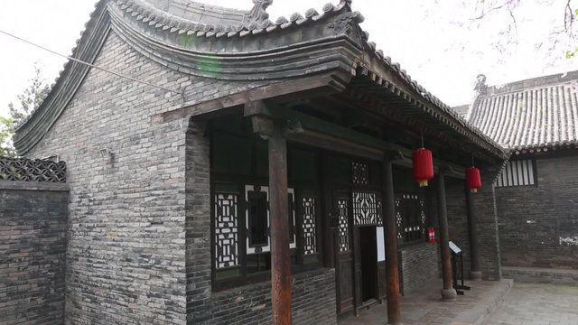 woman sweeps courtyard in the ancient city of pingyao china