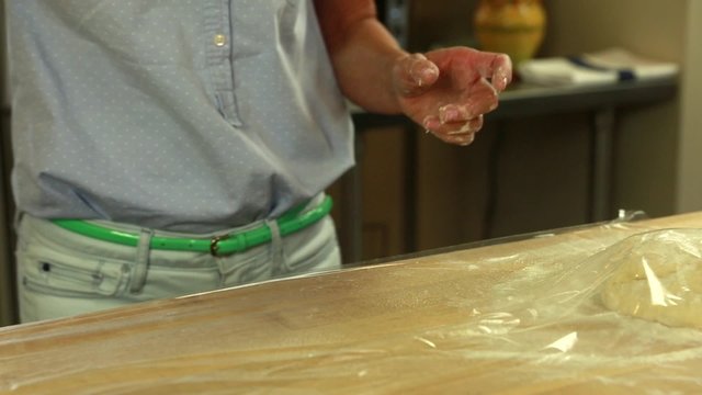 woman sprays pam on plastic while making bread