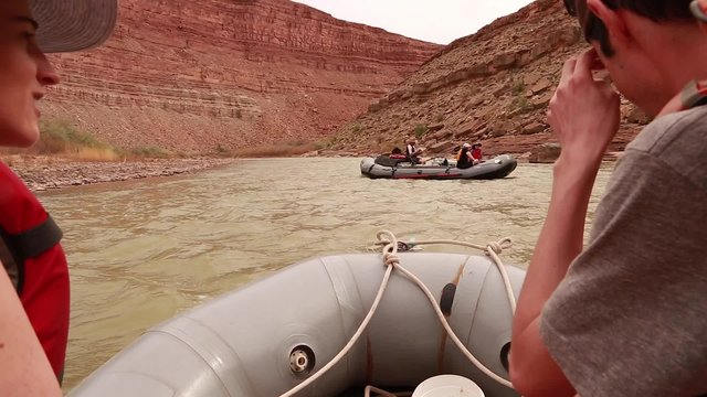 family running a river through a deep desert canyon