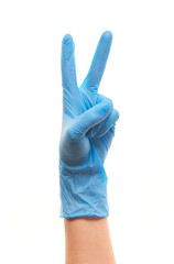 Female doctor's hand in blue surgical glove showing victory sign