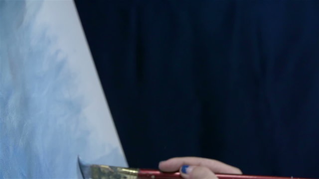 Close up on canvas while artist painting background