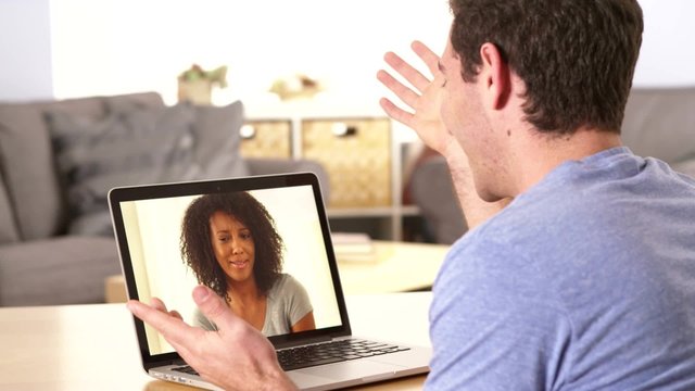 Man webcamming with friend on laptop