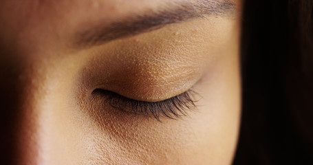 Close up of woman with closed eyes on black background