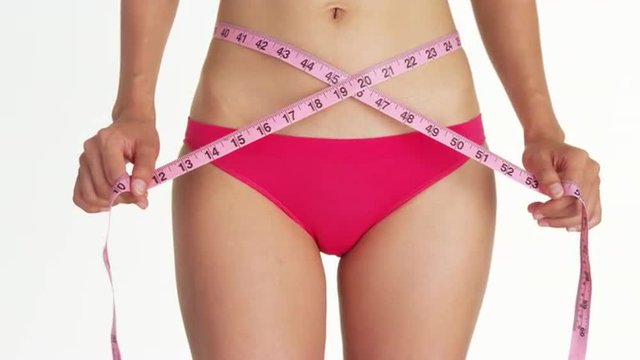 Closeup of sexy woman measuring waist