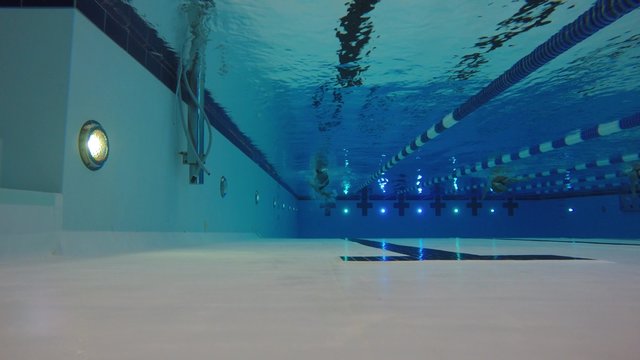 An underwater shot of a man swimming freestyle in a pool