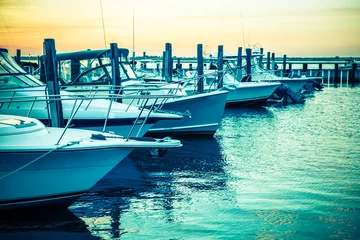 Fotobehang  Colorful sunset toned boats docked at marina © littleny