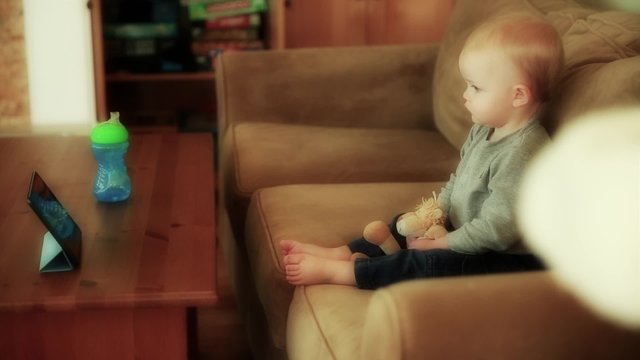 a baby boy watching show on the ipad