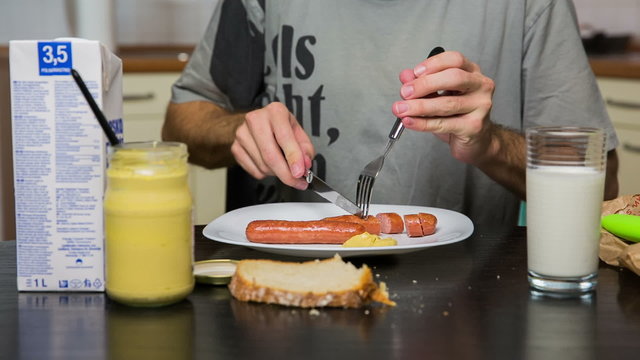 Table with hot-dogs, mustard and milk close up