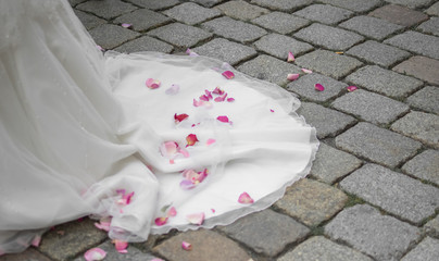 Blütenblätter auf dem Brautkleid