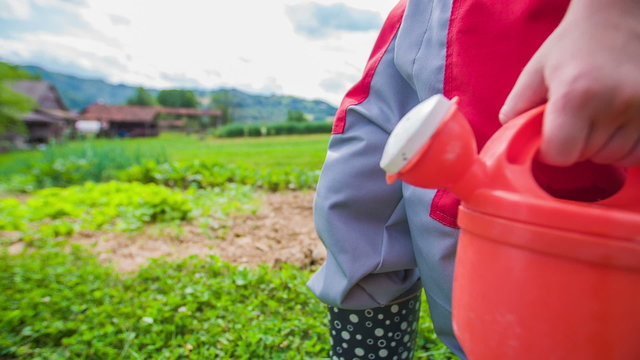 Little Gardener in Boots Walking With Small Water Bucker