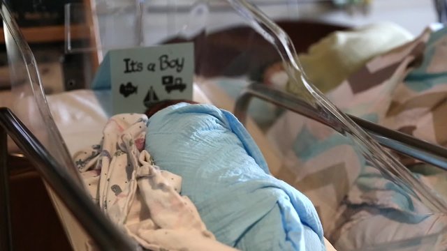 newborn boy sleeping with mother in hospital dolly shot