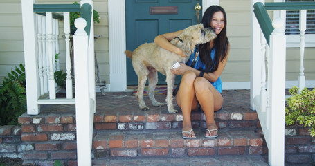 Young woman sitting on porch with her dog
