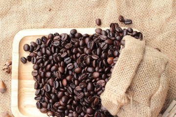 Roasted coffee beans on sack brown background.