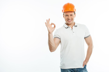 Cheerful young man with hardhat is expressing positive emotions