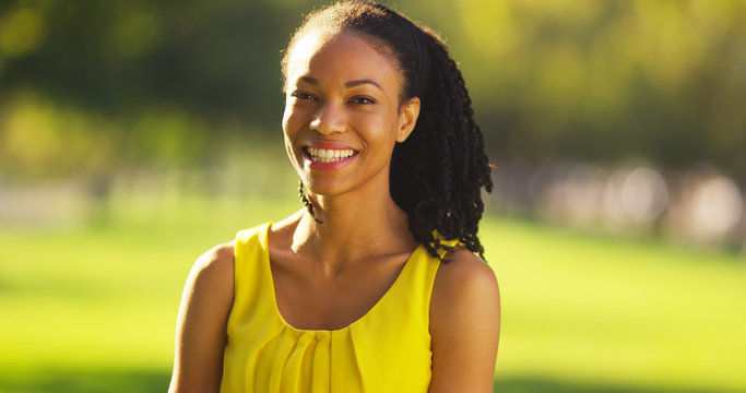 Happy black woman smiling in a park