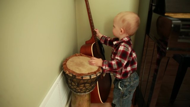 a little boy playing a guitar