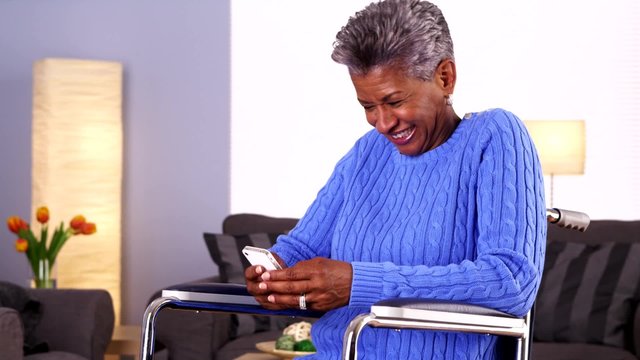 Mature black woman texting on smartphone