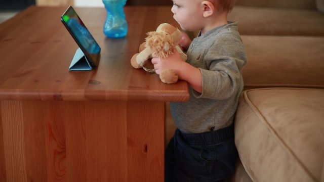 a cute boy watching movie on a tablet