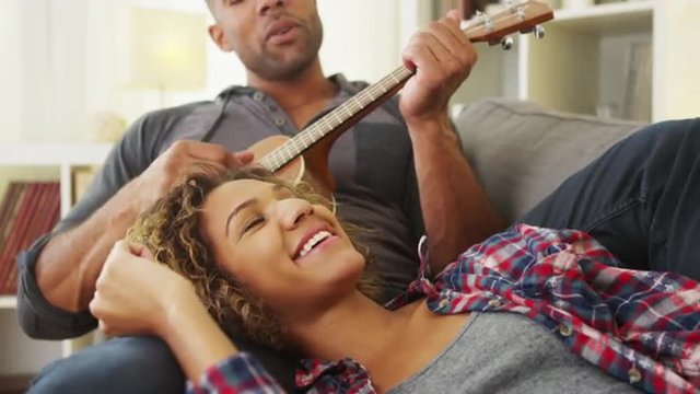 Black girlfriend enjoying being serenaded to by boyfriend